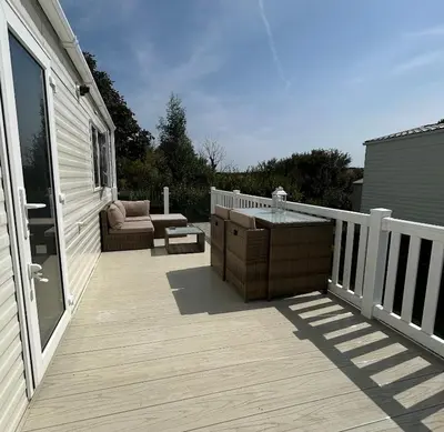 a wooden deck with a hot tub on a house at L20 at Seven Bays Park in St Merryn