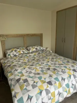 a bedroom with a bed with a colorful comforter at L20 at Seven Bays Park in St Merryn