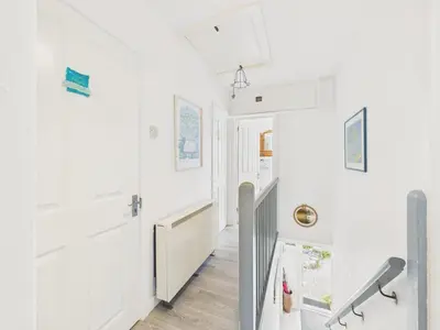 a hallway of a house with white walls and wooden floors at Seaside 2-bed Home in Flushing with Free Parking & sea views in Falmouth