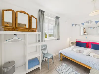a bedroom with a bunk bed and a blue chair at Seaside 2-bed Home in Flushing with Free Parking & sea views in Falmouth