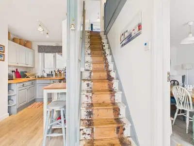 a stairwell in a kitchen with white walls and wood floors at Seaside 2-bed Home in Flushing with Free Parking & sea views in Falmouth