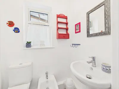 a bathroom with a sink and a toilet and a mirror at Seaside 2-bed Home in Flushing with Free Parking & sea views in Falmouth