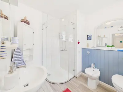 a bathroom with a shower and a toilet and a sink at Seaside 2-bed Home in Flushing with Free Parking & sea views in Falmouth