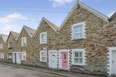 a row of brick houses with a pink door at 2 Bed in Wadebridge oc-m32567 in Wadebridge