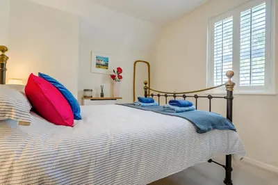 a bedroom with a bed with red and blue pillows at 2 Bed in Wadebridge oc-m32567 in Wadebridge