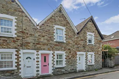 a brick house with a pink door on a street at 2 Bed in Wadebridge oc-m32567 in Wadebridge