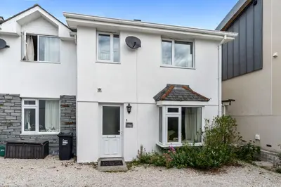 a white house with a white door at Macalby Cottage in Padstow
