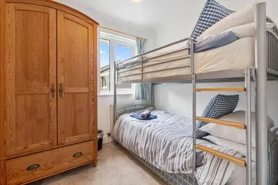 a bedroom with two bunk beds and a dresser at Macalby Cottage in Padstow