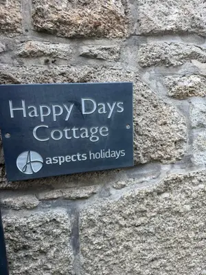 a sign for happy days conference on a brick wall at Happy days cottage in St Ives