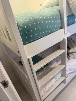 a bunk bed with white drawers in a bedroom at Happy days cottage in St Ives