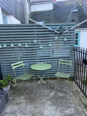 a table and two chairs in front of a wall at Happy days cottage in St Ives