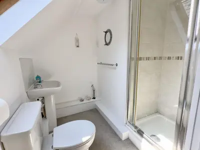 a bathroom with a shower and a toilet and a sink at Heather House in Padstow