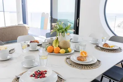 a white table with plates of fruit on it at Aurora Skies in Porthtowan