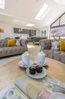 a living room with two cups and cupcakes on a table at Aurora Skies in Porthtowan