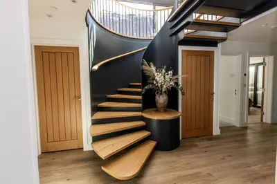 a spiral staircase in a house with a vase on it at Aurora Skies in Porthtowan