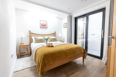 a bedroom with a bed with a yellow blanket at Aurora Skies in Porthtowan