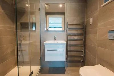 a bathroom with a toilet and a sink and a shower at Aurora Skies in Porthtowan