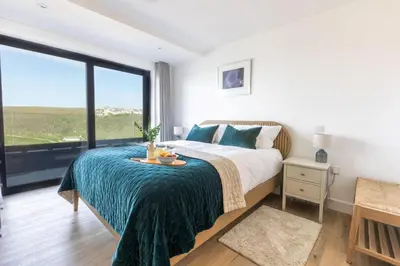 a bedroom with a bed and a large window at Aurora Skies in Porthtowan