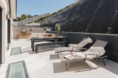 a patio with chairs and a table on a roof at Aurora Skies in Porthtowan