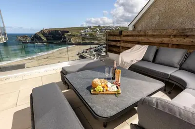a table with a plate of food on a balcony at Tides Edge in Portreath