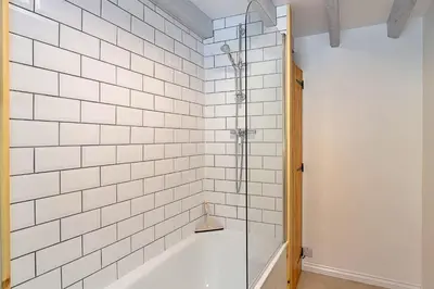 a bathroom with a shower with white tiled walls at Finest Retreats - Rowella Cottage in Blisland