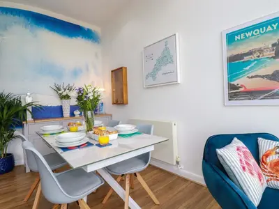 a dining room with a table and chairs at Penthouse 46Zinc - Headland View in Newquay