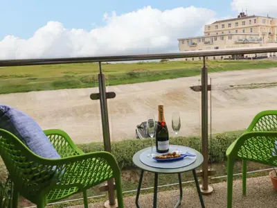 a table with a bottle of wine and a glass at Penthouse 46Zinc - Headland View in Newquay