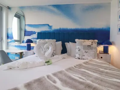 a bedroom with a bed with two swans on it at Penthouse 46Zinc - Headland View in Newquay