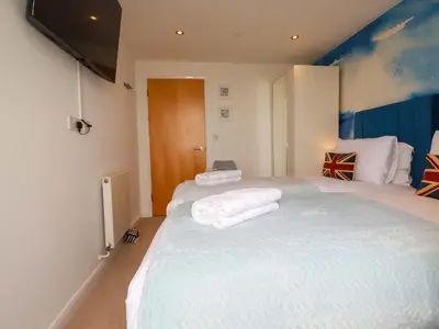 a bedroom with a large bed with towels on it at Penthouse 46Zinc - Headland View in Newquay