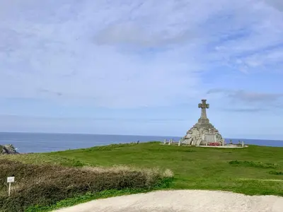 a lighthouse on top of a grassy hill next to the ocean at Penthouse 46Zinc - Headland View in Newquay