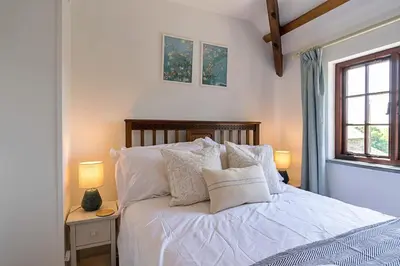 a bedroom with a bed with white sheets and pillows at Finest Retreats - Demelza Cottage in Blisland