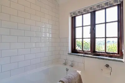a white bathroom with a tub and a window at Finest Retreats - Demelza Cottage in Blisland