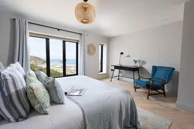 a bedroom with a bed with a view of the ocean at Tamarind Tide in Portreath