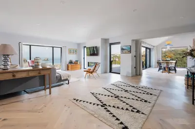 an open living room with a table and a desk at Tamarind Tide in Portreath