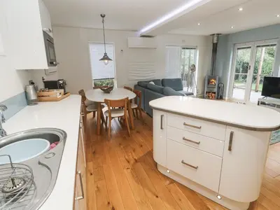 a kitchen and living room with a white counter top at The Black Barnacle in Redruth