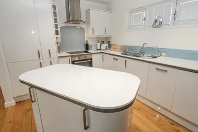 a kitchen with white cabinets and a white counter top at The Black Barnacle in Redruth