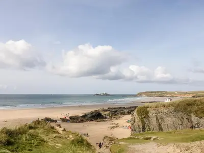 a beach with people on the sand and the ocean at The Black Barnacle in Redruth