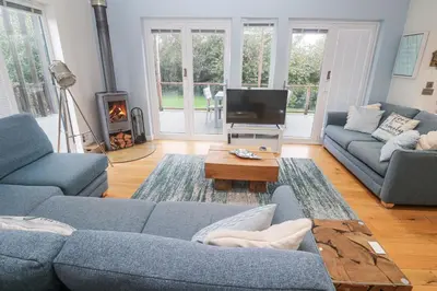a living room with a blue couch and a tv at The Black Barnacle in Redruth