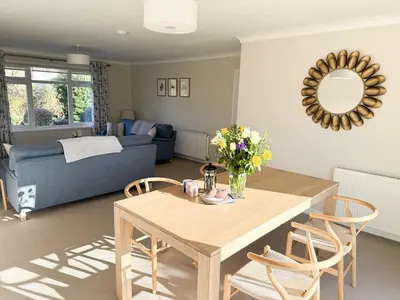 a living room with a table and a blue couch at 42 Little Trelyn in Wadebridge