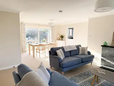 a living room with a blue couch and a table at 42 Little Trelyn in Wadebridge