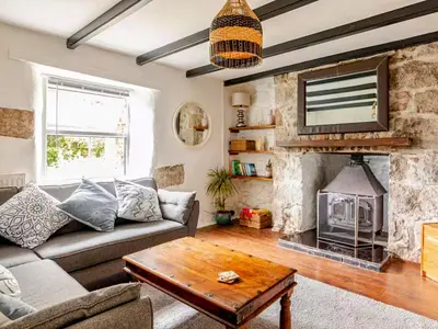 a living room with a couch and a fireplace at Sunnyside Cottage Retreat in St Austell