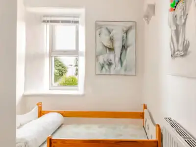 a white room with a bench and a window at Sunnyside Cottage Retreat in St Austell