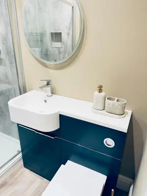 a bathroom with a blue and white sink and a mirror at Rising Sun Inn - Rough Tor in Altarnun