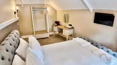 a hotel room with a bed and a dressing table at Rising Sun Inn - Rough Tor in Altarnun
