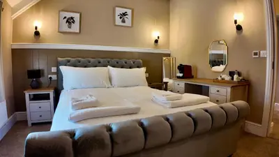 a bedroom with a large bed with towels on it at Rising Sun Inn - Bronn Ewhella in Altarnun