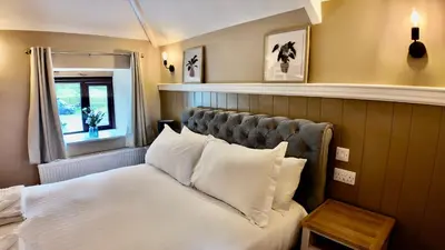a bedroom with a bed with white pillows and a window at Rising Sun Inn - Bronn Ewhella in Altarnun