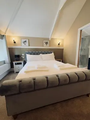 a bedroom with a large bed with a couch at Rising Sun Inn - Bronn Ewhella in Altarnun