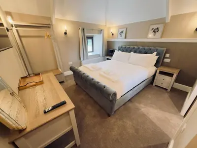a small bedroom with a bed and a table at Rising Sun Inn - Bronn Ewhella in Altarnun