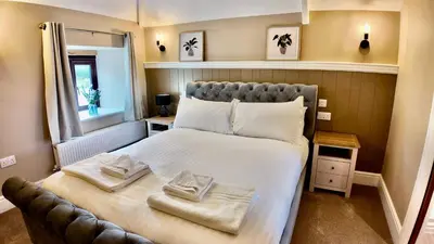 a bedroom with a large bed with towels on it at Rising Sun Inn - Bronn Ewhella in Altarnun
