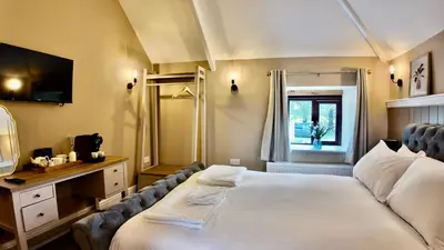 a hotel room with a bed and a mirror at Rising Sun Inn - Bronn Ewhella in Altarnun